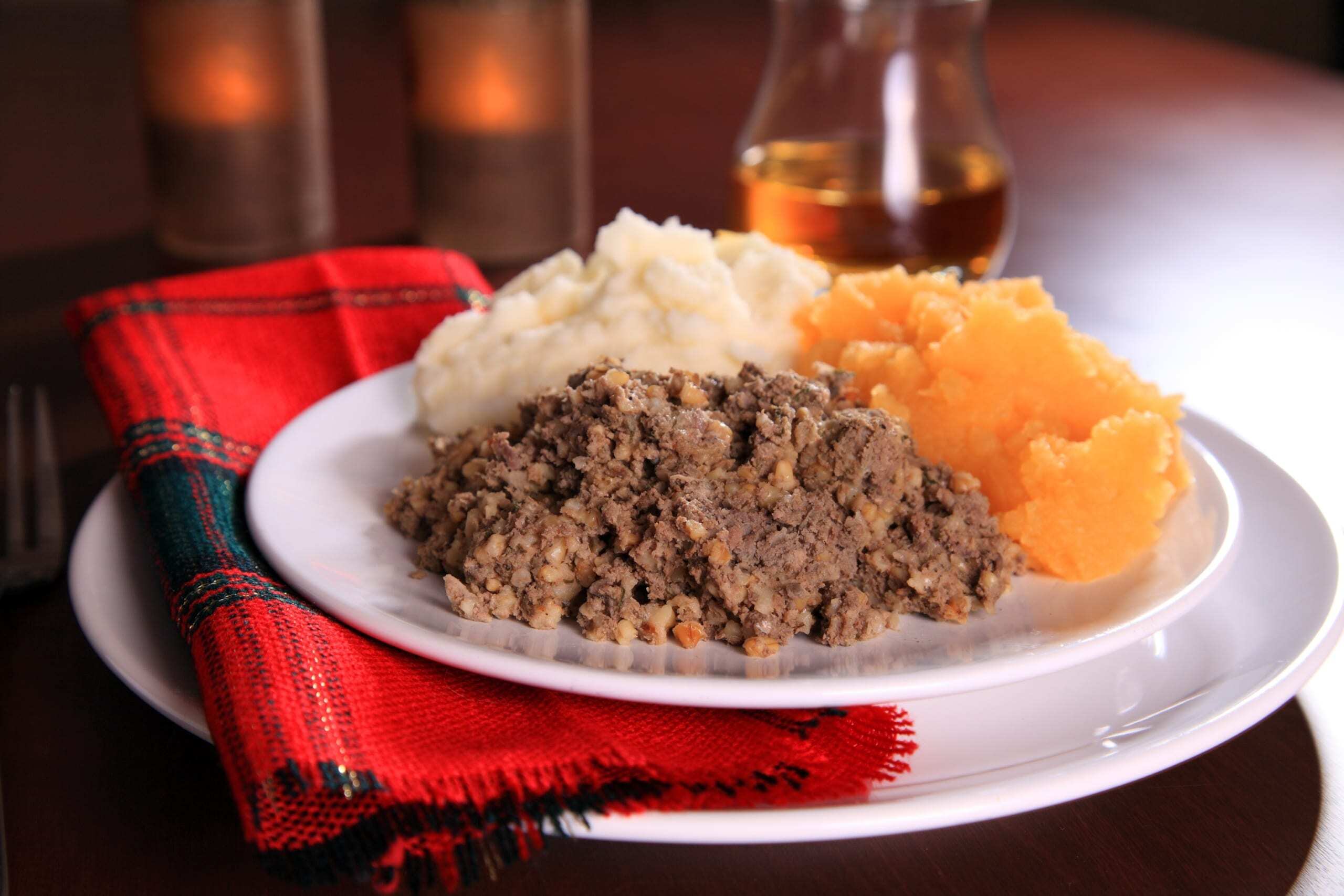 A Burns Night supper of haggis and tatties on a plate with a tartan napkin. A Burns Night supper of haggis and tatties on a plate with a tartan napkin.