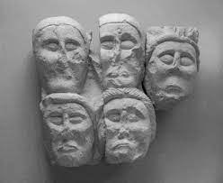 Five Celtic stone faces on a wall. Five Celtic stone faces on a wall.