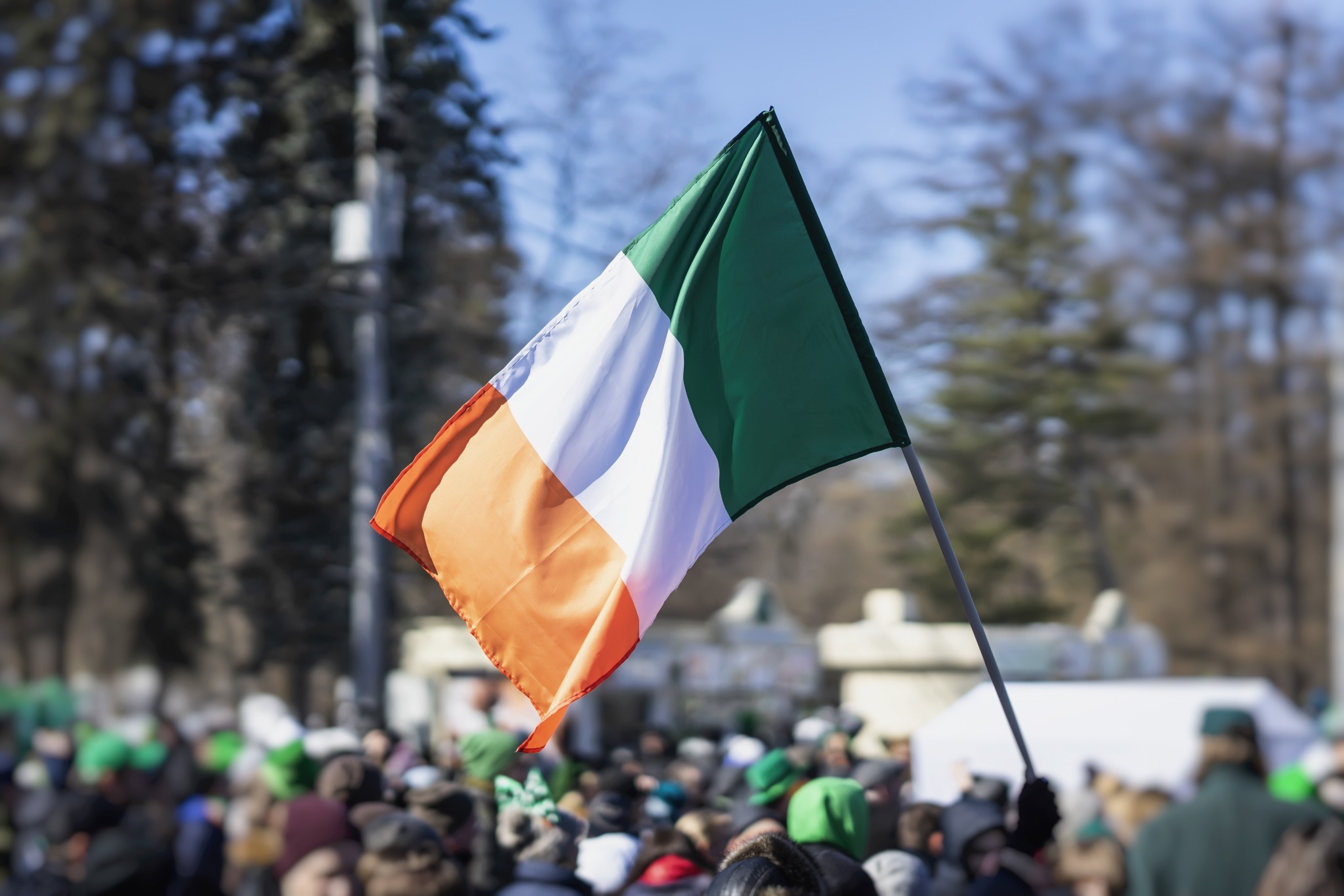 An Irish flag at a St. Patrick's Day parade. An Irish flag at a St. Patrick's Day parade.