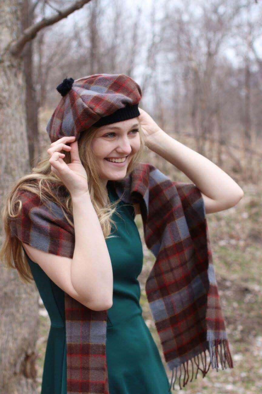 A girl smiling and wearing an OUTLANDER Tam Premium Lambswool Tartan tam and scarf. A girl smiling and wearing an OUTLANDER Tam Premium Lambswool Tartan tam and scarf.