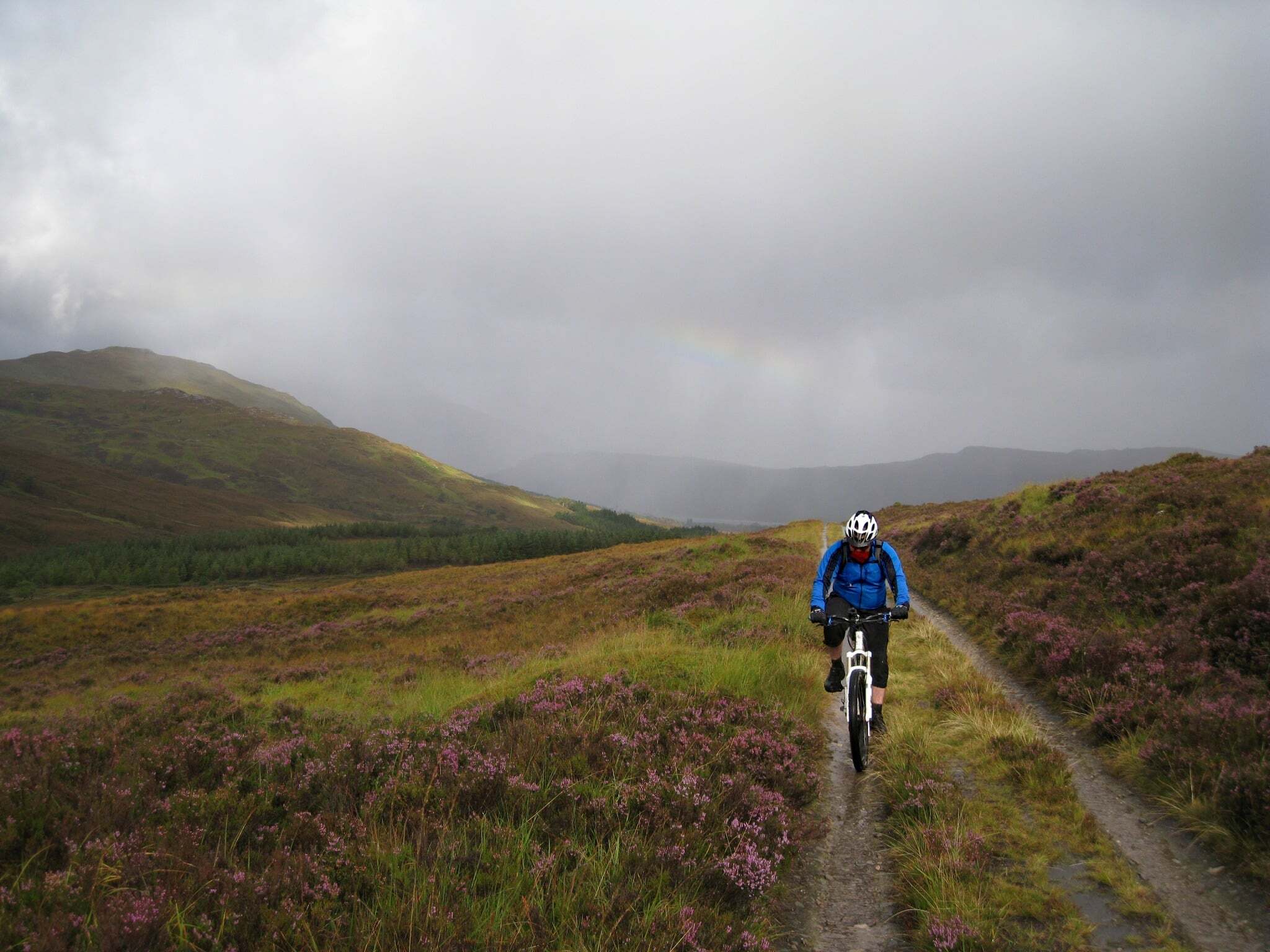 A cyclist riding in the rain in the Scottish Highlands A cyclist riding in the rain in the Scottish Highlands