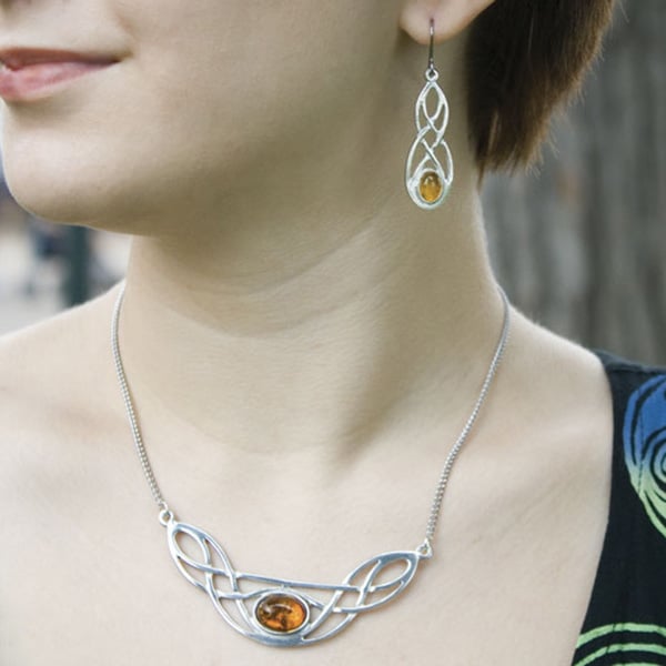 A woman wearing Celtic-inspired jewelry that was given as a Scottish gift